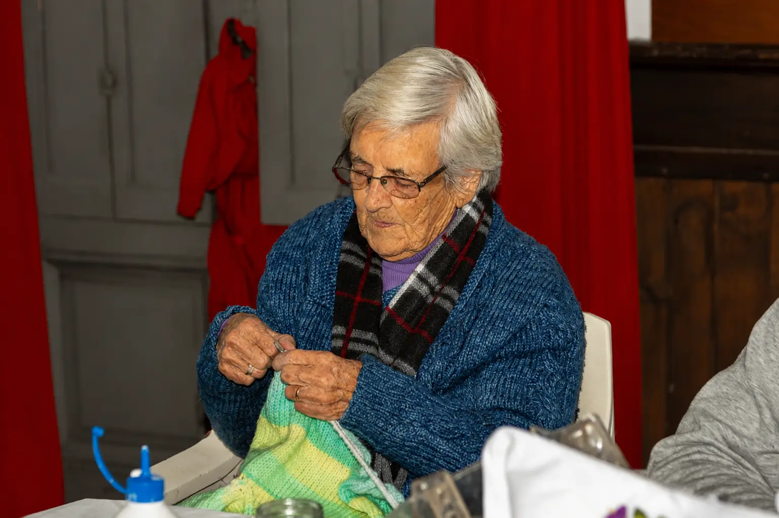 Mientras el frío arrecia, Genoveva González, de 100 años, teje para los niños en un programa solidario